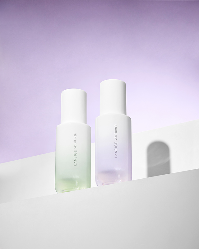 Veil primer mint green color, pure violet color product, standing side by side on a stage under a purple background