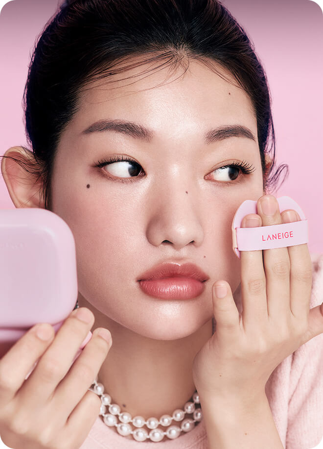 모델이 네오 쿠션 더 글로우를 퍼프로 얼굴에 바르는 모습