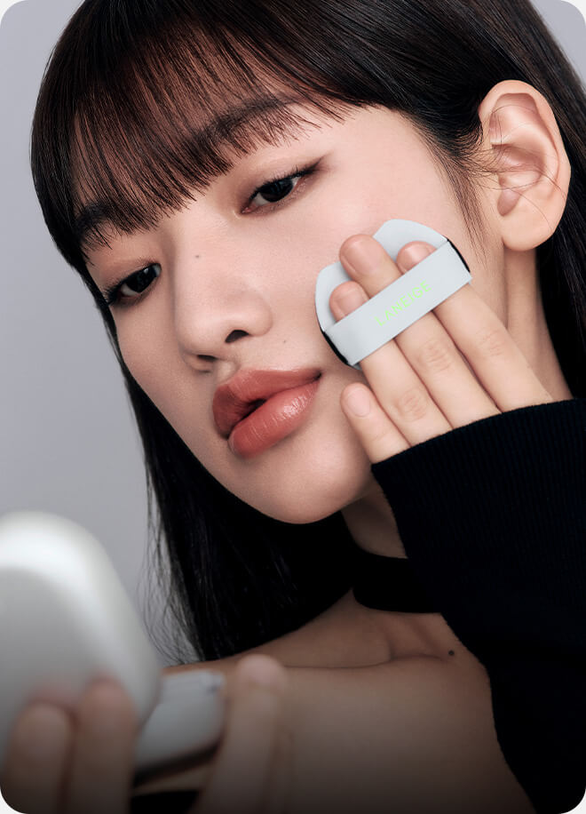모델이 네오 쿠션 더 매트를 퍼프로 얼굴에 바르는 모습